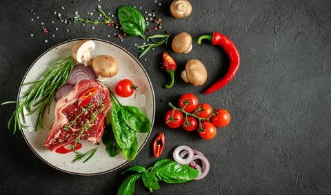 Veal bone cue ball on plate with vegetables, herbs and spices. Meat cooking.. Stockfoto's
