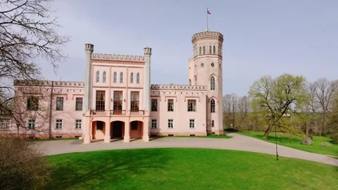 Vecauce Palace in Latvia With Waving Flag and Pink Castle Walls, Spring Morning Stock Footage 320104026