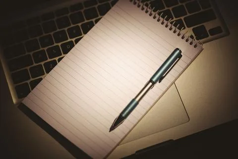 Vector art showing notepad lying across laptop keyboard palm rest with ballpoint Stock Photos