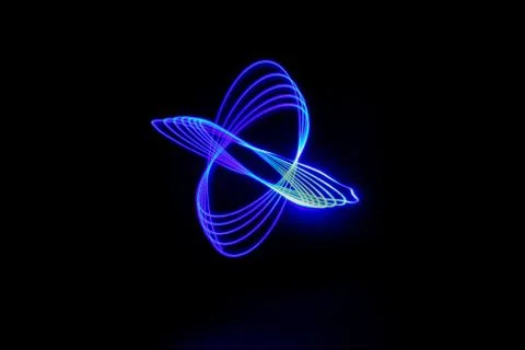 A vector blue neon light intertwined circle trail on a black background - gre Stock Photos