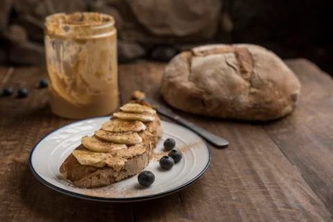 Vegan breakfast, slice of rustic bread with peanut butter Stock Photos