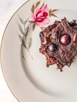 Vegan brownies with berries stack in a vintage white plate Stock Photos