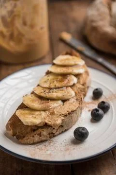 Vegan brunch with toasted rustic bread with peanut butter and banana Stock Photos
