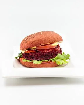 Vegan burger with beetroot cutlet, vegetables and grain bun. Isolate on a white Stock Photos