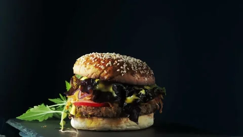 Vegan burger revolves on a slate plate. Video stock 197549058