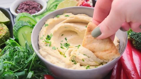 Vegan charcuterie board. Hummus bowl with vegetables, fried chickpeas, olives Stock Footage 148554367