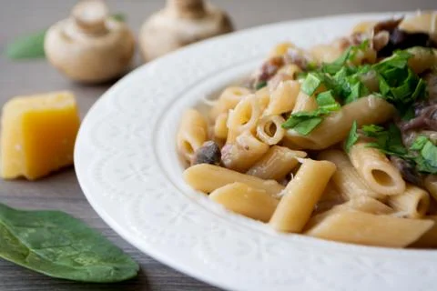 Vegan creamy mushroom garlic pasta garnished with basil Stock Photos