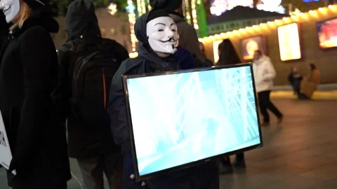 Vegan demonstrator wearing face mask standing at Leicester Square Stock Footage 166307280