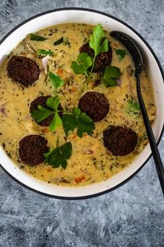 Vegan green curry with mixed vegetables and plant-based meatballs, healthy pl Stock Photos