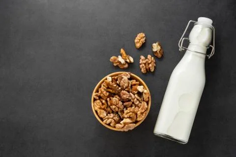 Vegan milk from walnuts ondark background with copy space, top view. Stock Photos
