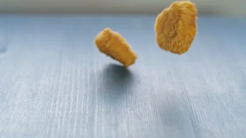 Vegan plant based nuggets falling on table in slow motion Stock Footage 115794489