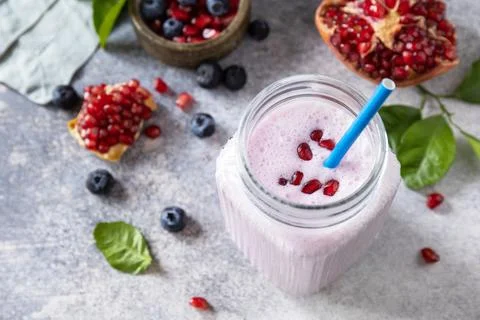 Vegan protein smoothie made from pomegranate and blueberry on a stone tableto Stock Photos