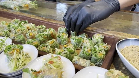 Vegan rolls with greens and stuffing wrapped in cling film and lie on board. Stock Footage 245339971