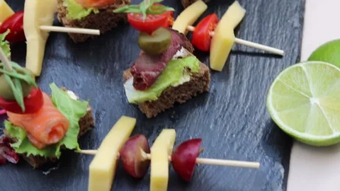 Vegan snacks on black kitchen board, cheese, berries and lime Stock Footage 158323346