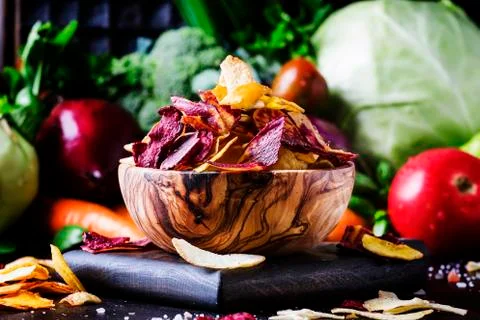 Vegan snacks, multicolored vegetable chips in  wooden bowl, background from Stock Photos