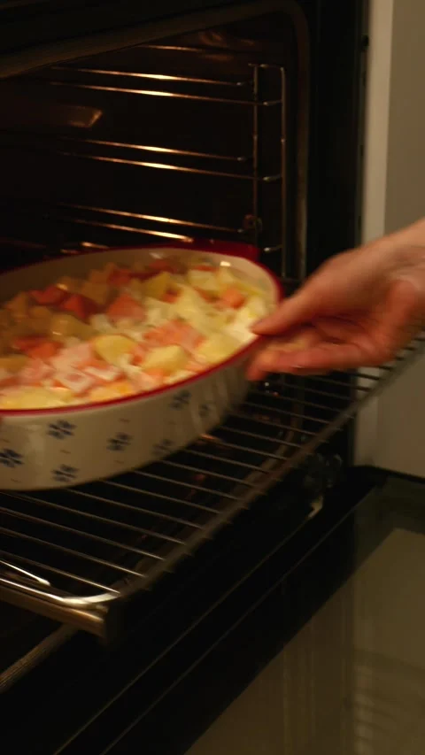 Vegan vegetable casserole ready for baking placed on oven rack 스톡 동영상 328426421