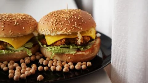 Vegetable Burger with chickpea cutlet. Two burgers on black plate Stock Photos