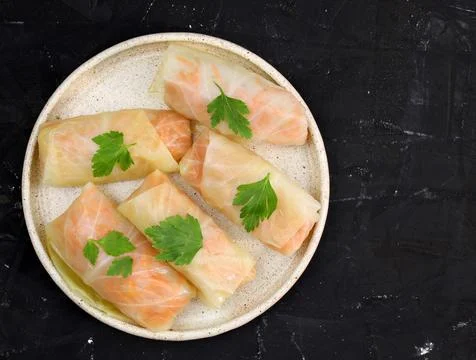 Vegetable cabbage rolls in a plate on a black background top view. Stock Photos