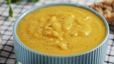 Vegetable cream soup close-up served with aromatic spices and bread. Video stock 330537470