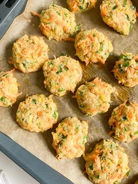 Vegetable cutlets are placed on a baking tray lined with parchment paper. T.. Stock Photos