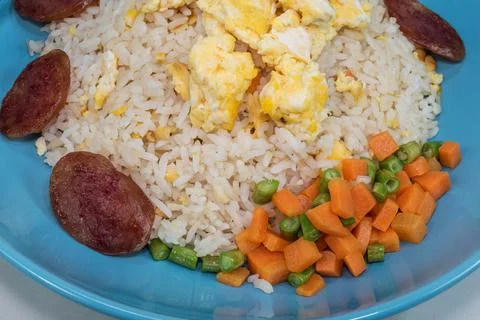 Vegetable fried rice with sausage egg carrot bean on white table. Stock Photos