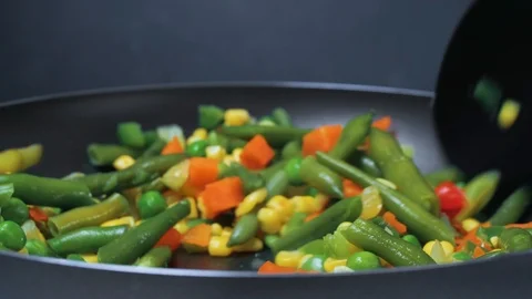 The vegetable mix is fried in a frying pan. Spoon the vegetables mixed. 4k Video stock 89842196