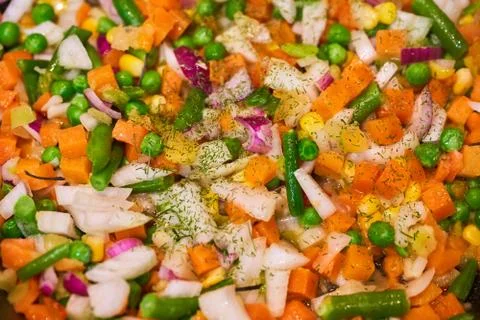 The vegetable mixture is fried in a pan. Close-up shooting Stock Photos
