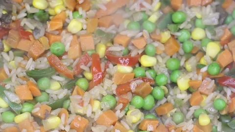 Vegetable mixture of rice green peas corn pepper and carrots are preparing Stock Footage 130769971