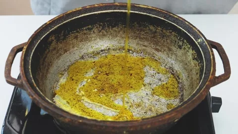 Vegetable oil is poured into a deep cast-iron frying pan. Medium shot. 스톡 동영상 340521980