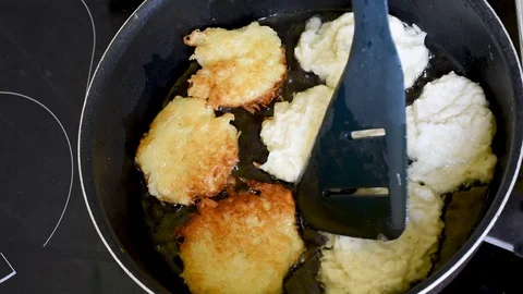 Vegetable pancakes are cooked in vegetable oil in a frying pan Stock Footage 94014842