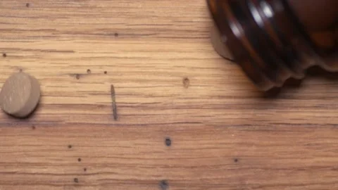 Vegetable pills pour and fall on a wooden table Stock Footage 168642455