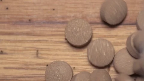 Vegetable pills pour and fall on a wooden table Video stock 168642753