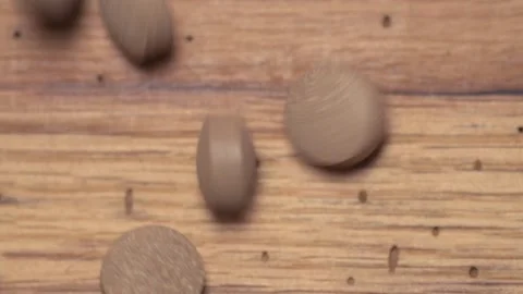 Vegetable pills pour and fall on a wooden table Video stock 168642804