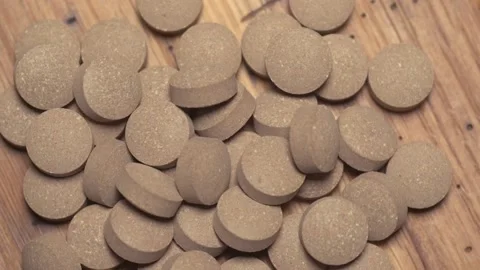 Vegetable pills pour and fall on a wooden table Video stock 168643115