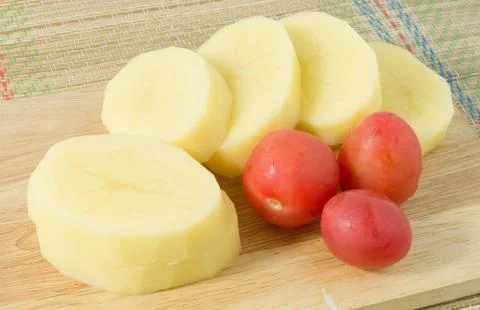 Vegetable, Raw Slice Potatoes and Fresh Tomatoes on A Wooden Cutting Board. Stock Photos