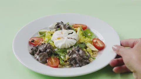 Vegetable salad and poached eggs. plate with salad on a green background. hand Stock-Footage 139858503