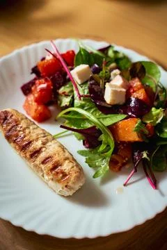 Vegetable salad with beetroot and pumpkin on a white plate with grilled chick Stock Photos