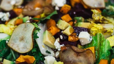 Vegetable salad of caramelized pear, beetroot, arugula, avocado, carrot, with Foto stock
