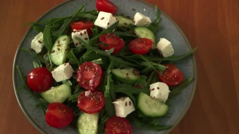 Vegetable salad with cheese, tomatoes, cucumbers, arugula on a beautiful plate Video stock 219694091