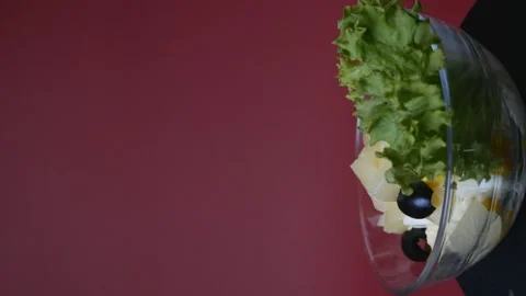 Vegetable salad with pineapple in a rotating glass plate on a burgundy Stock Footage 170775362