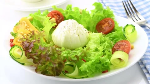 Vegetable salad with poached egg. A boiled egg is laid out on a plate with fresh Stock Footage 146155036