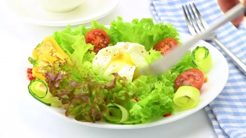Vegetable salad with poached egg. A boiled egg is laid out on a plate with fresh Stock Footage 146155042