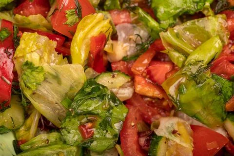 Vegetable salad of sliced tomatoes, cucumbers, sweet peppers, radishes and he Stock Photos