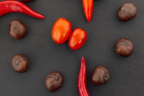 Vegetable set red tomato mini in the center of a brown chestnut brown chili p Stock Photos