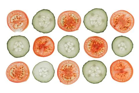 Vegetable slices in symmetrical pattern, red tomatoes contrast green cucumber Stock Photos