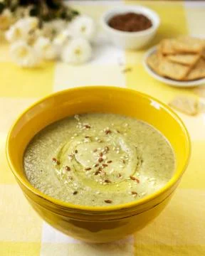 Vegetable soup with broccoli, served with crackers, linseed oil and seeds. Stock Photos