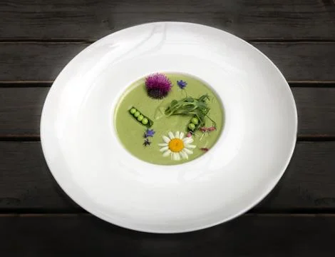 Vegetable soup mashed green peas and broccoli, decorated with flowers and Stock Photos