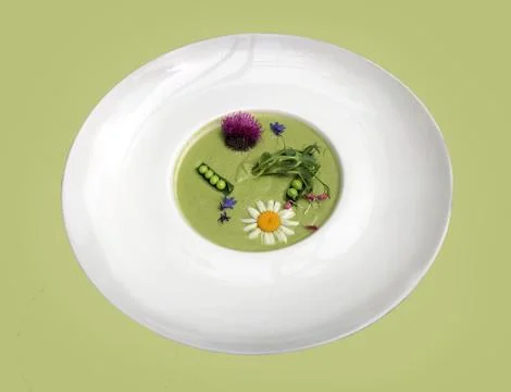 Vegetable soup mashed green peas and broccoli, decorated with flowers and fra Stock Photos
