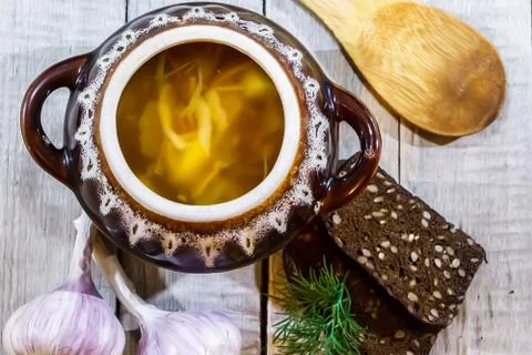 Vegetable soup in a pot with bread and fresh garlic on a gray wooden backgrou Foto stock
