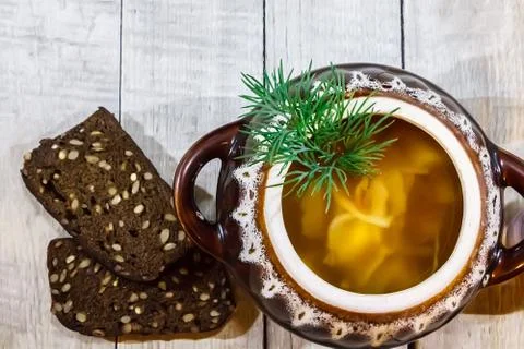 Vegetable soup in a pot with bread and fresh garlic on a gray wooden backgrou Stock Photos